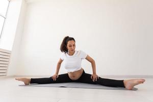 gezielte schwangere Frau trainiert während des Yoga-Kurses und entspannt sich, während sie auf einer Matte auf dem Boden sitzt. Konzept der körperlichen und geistigen Vorbereitung des Körpers auf die Geburt. Platz für Texte foto