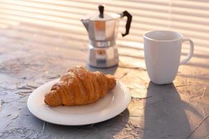 Frühstück mit Croissant und Mokkakanne. Morgenmahlzeit und Frühstückskonzept. foto