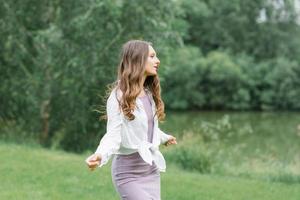 eine glückliche Frau in der Natur. Porträt eines schönen Mädchens in Nahaufnahme auf dem Hintergrund des Sees. Porträt der jungen lächelnden Frau im Freien. foto