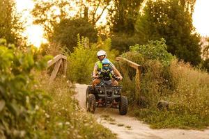 kleiner Junge mit Ausbilder auf einem Quad foto