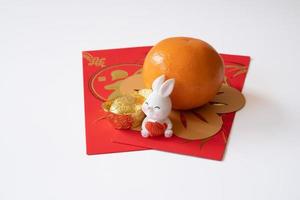 chinesisches neujahr des kaninchenfestivalkonzepts. Mandarine, Hase und Goldbarren isoliert auf weißem Hintergrund. foto
