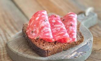 Sandwich mit Salami auf dem Holzbrett foto