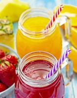 orangen- und erdbeersaft im glas auf altem blauem holztisch foto