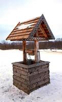 Holzbrunnen im Winterwald. ländliche Landschaft foto