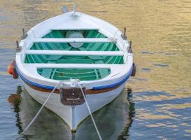 Weißes festgemachtes Boot auf einem Fluss ist Ozean mit Seil und Reflexion foto