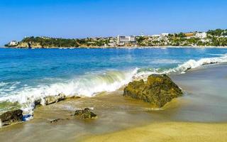 große surferwellen und felsen am strand puerto escondido mexiko. foto