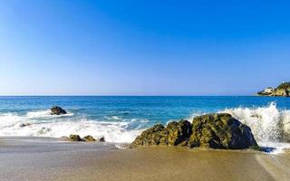 große surferwellen und felsen am strand puerto escondido mexiko. foto