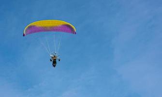 Gleitschirm mit Motor fliegt in den blauen Himmel foto