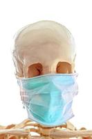 menschlicher schädel in einfacher dünner medizinischer maske zum schutz vor virusinfektionen foto