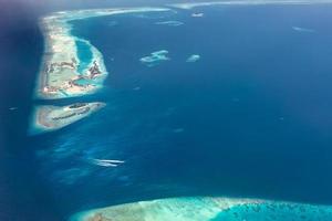 luftbild der malediven inseln und atolle. malediven tourismus und reisehintergrund. erstaunliche Aussicht auf das blaue Meer, das Korallenriff und die Atoll-Drohne. schöne naturlandschaft, seelandschaft, exotisches ziel foto