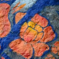 Fragment von Graffiti-Zeichnungen. Die alte Wand ist mit Farbflecken im Stil der Straßenkunstkultur dekoriert. orangene Blume foto