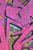 Fragment von Graffiti-Zeichnungen. Die alte Wand ist mit Farbflecken im Stil der Straßenkunstkultur dekoriert. farbige Hintergrundtextur in violetten Tönen foto