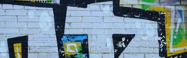 Fragment von Graffiti-Zeichnungen. Die alte Wand ist mit Farbflecken im Stil der Straßenkunstkultur dekoriert. farbige Hintergrundtextur foto