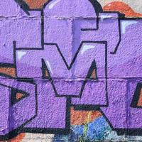 Fragment von Graffiti-Zeichnungen. Die alte Wand ist mit Farbflecken im Stil der Straßenkunstkultur dekoriert. farbige Hintergrundtextur in violetten Tönen foto