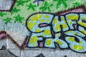 Fragment von Graffiti-Zeichnungen. Die alte Wand ist mit Farbflecken im Stil der Straßenkunstkultur dekoriert. farbige Hintergrundtextur in Grüntönen foto