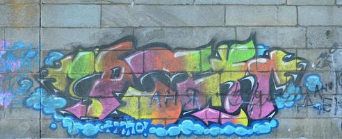 Fragment von Graffiti-Zeichnungen. Die alte Wand ist mit Farbflecken im Stil der Straßenkunstkultur dekoriert. mehrfarbige Hintergrundtextur foto
