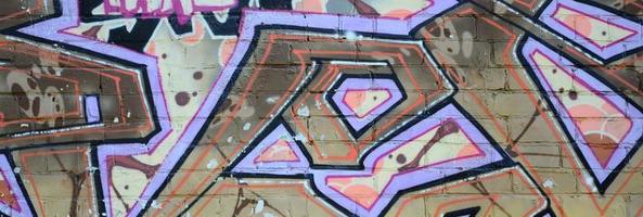 Fragment von Graffiti-Zeichnungen. Die alte Wand ist mit Farbflecken im Stil der Straßenkunstkultur dekoriert. farbige Hintergrundtextur in warmen Tönen foto