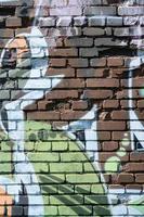 Fragment von Graffiti-Zeichnungen. Die alte Wand ist mit Farbflecken im Stil der Straßenkunstkultur dekoriert. farbige Hintergrundtextur in warmen Tönen foto