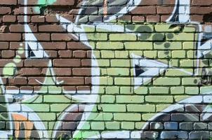 Fragment von Graffiti-Zeichnungen. Die alte Wand ist mit Farbflecken im Stil der Straßenkunstkultur dekoriert. farbige Hintergrundtextur in warmen Tönen foto