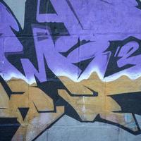 Fragment von Graffiti-Zeichnungen. Die alte Wand ist mit Farbflecken im Stil der Straßenkunstkultur dekoriert. farbige Hintergrundtextur in violetten Tönen foto