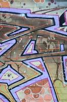 Fragment von Graffiti-Zeichnungen. Die alte Wand ist mit Farbflecken im Stil der Straßenkunstkultur dekoriert. farbige Hintergrundtextur in warmen Tönen foto