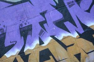 Fragment von Graffiti-Zeichnungen. Die alte Wand ist mit Farbflecken im Stil der Straßenkunstkultur dekoriert. farbige Hintergrundtextur in violetten Tönen foto