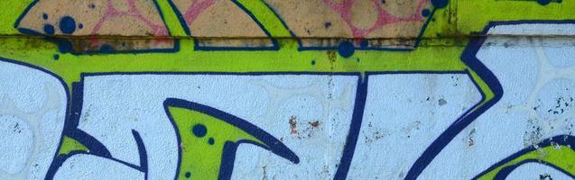 Fragment von Graffiti-Zeichnungen. Die alte Wand ist mit Farbflecken im Stil der Straßenkunstkultur dekoriert. farbige Hintergrundtextur in Grüntönen foto
