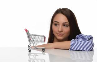 Frau dachte ans Einkaufen. Mädchen denkt ans Einkaufen. Frau entscheidet, wo sie einkaufen möchte. Frau Käufer mit Mini-Trolley aus dem Supermarkt. foto