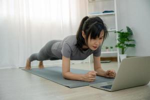 asiatische Frauen machen Planking-Übungen, um Bauchmuskeln aufzubauen. trainieren Sie regelmäßig für einen gesunden Körper. foto