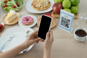 frau verwendet smartphone, um qr-code zu scannen, um im caférestaurant mit einer digitalen zahlung ohne bargeld zu bezahlen. Menü wählen und bestellen Rabatt kumulieren. E-Geldbörse, Technologie, online bezahlen, Kreditkarte, Bank-App foto