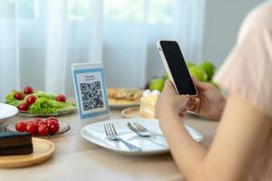 frau verwendet smartphone, um qr-code zu scannen, um im caférestaurant mit einer digitalen zahlung ohne bargeld zu bezahlen. Menü wählen und bestellen Rabatt kumulieren. E-Geldbörse, Technologie, online bezahlen, Kreditkarte, Bank-App