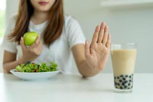 Frauen lehnen Junk Food oder ungesunde Lebensmittel wie Donuts ab und wählen gesunde Lebensmittel wie grüne Äpfel und Salate. konzept des fastens und der guten gesundheit. foto