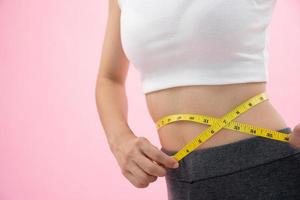 Ernährung und Diät. Schönheit schlanker weiblicher Körper mit Maßband. frau in trainingskleidung erreicht gewichtsverlustziel für ein gesundes leben, verrückt nach dünnheit, dünner taille, ernährungsberaterin.