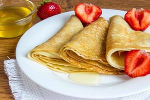 Crêpes-Stapel mit Erdbeer- und Honigsirup foto