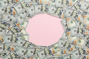 Rahmen von Hundert-Dollar-Scheinen mit leerem Platz für Ihr Design. Draufsicht des Geschäftskonzepts auf rosa Hintergrund mit Kopienraum foto