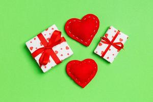 Draufsicht auf farbenfrohen Valentinshintergrund aus Geschenkboxen und roten Textilherzen. Valentinstag-Konzept foto