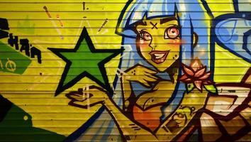 die Textur der Wand, dekoriert in Graffiti-Zeichnung mit dem Bild eines hübschen Mädchens mit blauen Haaren foto