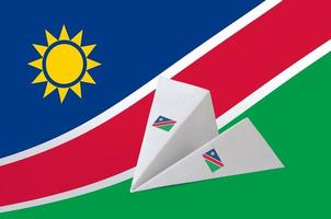 Namibia-Flagge auf Papier-Origami-Flugzeug abgebildet. handgemachtes kunstkonzept foto