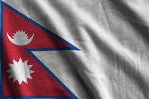 nepal-flagge mit großen falten, die nah oben unter dem studiolicht innen winken. die offiziellen symbole und farben im banner foto