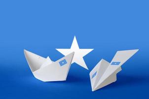 somalia flagge auf papier origami flugzeug und boot dargestellt. handgemachtes kunstkonzept foto