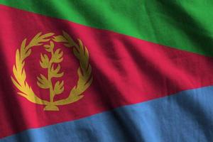 eritrea-flagge mit großen falten, die unter dem studiolicht im innenbereich wehen. die offiziellen symbole und farben im banner foto