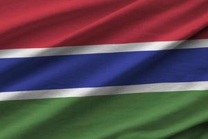 Gambia-Flagge mit großen Falten, die im Innenbereich unter dem Studiolicht wehen. die offiziellen symbole und farben im banner foto