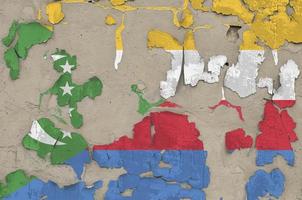 Komoren-Flagge in Lackfarben auf alter, veralteter, unordentlicher Betonwand in Nahaufnahme dargestellt. strukturierte Fahne auf rauem Hintergrund foto