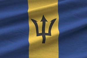 barbados-flagge mit großen falten, die unter dem studiolicht im innenbereich wehen. die offiziellen symbole und farben im banner foto