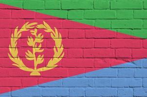 Eritrea-Flagge in Lackfarben auf alter Ziegelwand dargestellt. strukturiertes banner auf großem backsteinmauermauerwerkhintergrund foto