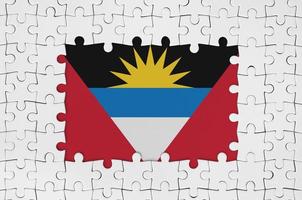 Antigua- und Barbuda-Flagge im Rahmen aus weißen Puzzleteilen mit fehlendem Mittelteil foto