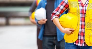 ingenieurteam hält helm, schutzhelm, für sicherheitsteamarbeit auf der baustelle in der industrie foto