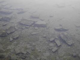 Felsen durch trübes Wasser am Grund des Sees foto