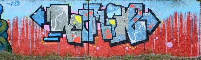 vollständiges und vollendetes Graffiti-Kunstwerk. Die alte Wand ist mit Farbflecken im Stil der Straßenkunstkultur dekoriert. farbige Hintergrundtextur foto
