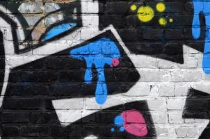 Fragment von Graffiti-Zeichnungen. Die alte Wand ist mit Farbflecken im Stil der Straßenkunstkultur dekoriert. farbige Hintergrundtextur foto